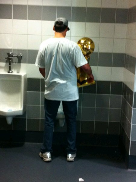 No pics of the billboard yet, so heres Mark Cuban at a urinal with the NBA championship trophy.